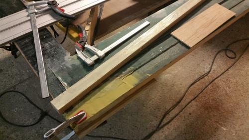 Nieuw hout wordt passend gemaakt en geklemd in een oude deur.