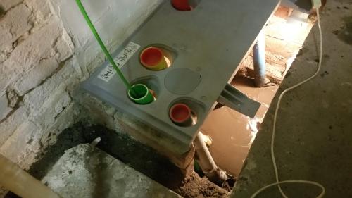The still-liquid floor beneath the meter cupboard, beside the base plate and service ducts.