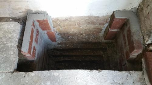 New brickwork on either side of the floor opening, forming the foundation for the meter cupboard.