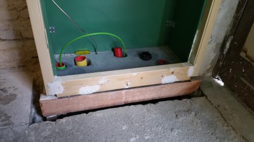 Detail of the frame, green interior and woodwork at the bottom of the cupboard.