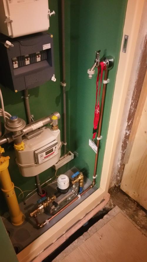 Inside the meter cupboard, showing meters, pipework and a tap.